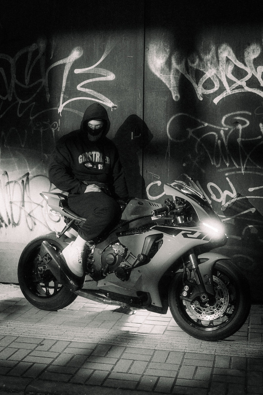 Hurt.Biker rider on a sportbike in front of a graffiti wall